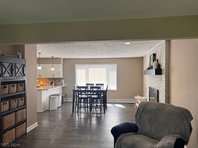 2760 Haines Road Madison, OH 44057 - Photo 17 of 33 Open-concept living space with dark wood-finish flooring, a white brick fireplace with a dark mantel, and recessed lighting