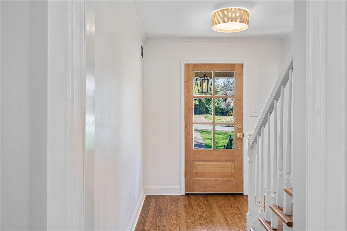 5600 Normandy Road Memphis, TN 38120 - Photo 6 of 28 Entryway featuring stairway, visible vents, wood finished floors, and crown molding