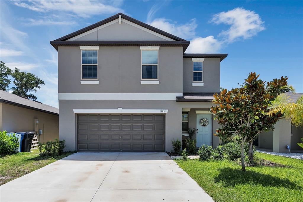a front view of a house with a yard and garage