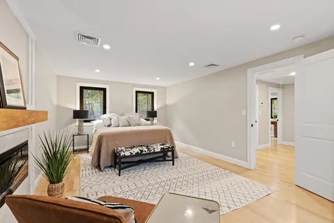 a spacious bedroom with a bed a couch and a potted plant