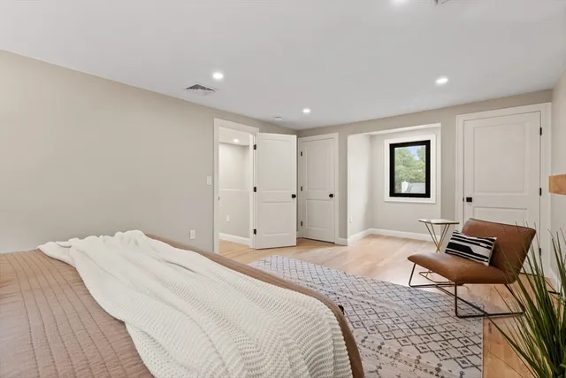 a spacious bedroom with a bed and chair