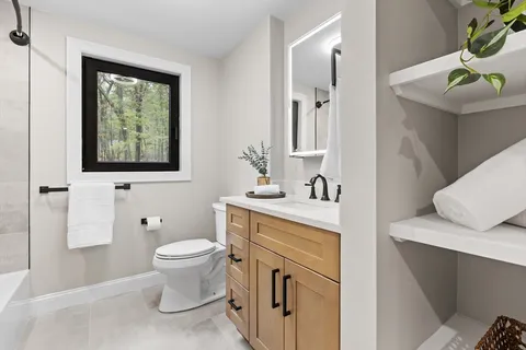a bathroom with a toilet sink and mirror