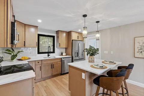 a kitchen with a sink stove and chairs