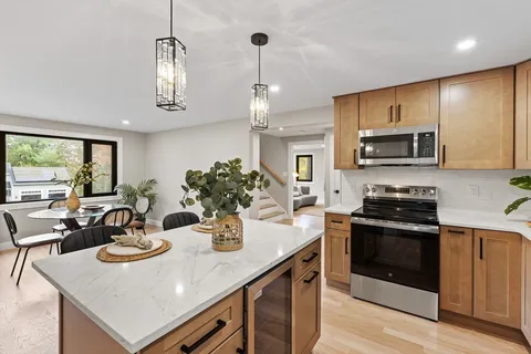 a kitchen with a sink a stove and chairs
