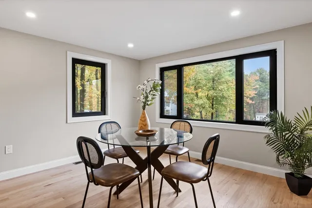 a dining room with furniture and potted plants