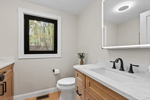 a bathroom with a toilet sink and mirror