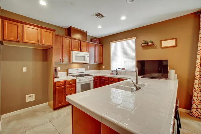 a large kitchen with stainless steel appliances granite countertop a sink and cabinets
