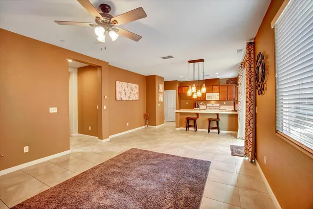 a view of a livingroom with furniture a ceiling fan and window