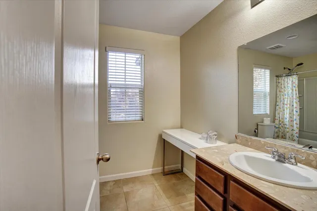 a bathroom with a shower curtain and a window