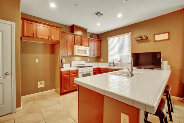 a large kitchen with stainless steel appliances granite countertop a sink and cabinets