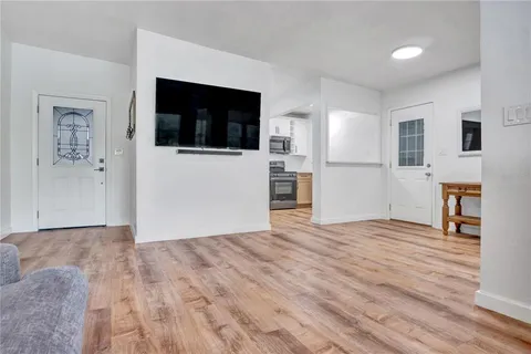 a view of empty room with wooden floor and fireplace