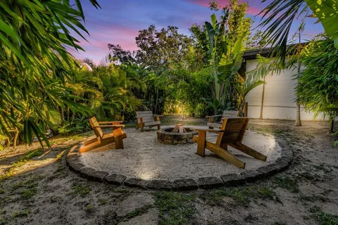 a backyard of a house with fountain table and chairs