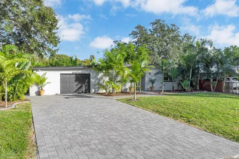 front view of a house with a yard and an trees