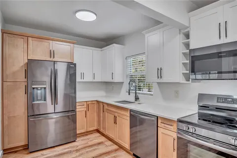 a kitchen with stainless steel appliances a refrigerator sink and cabinets
