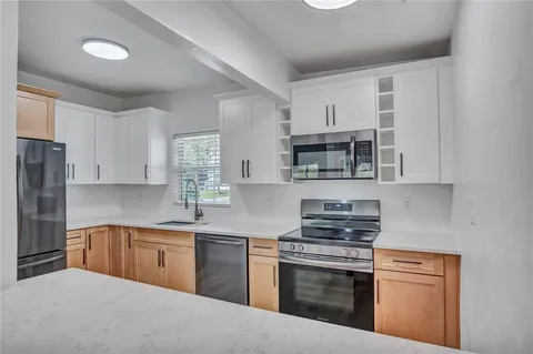 a kitchen with cabinets a sink and stainless steel appliances