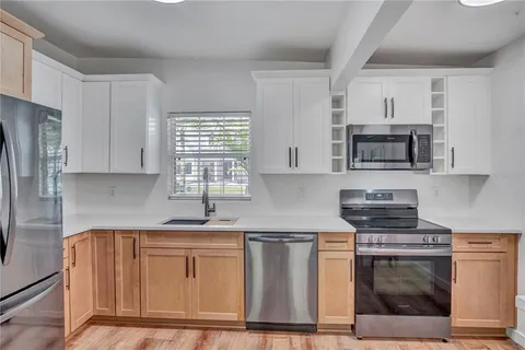 a kitchen with cabinets stainless steel appliances and a counter space