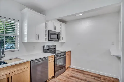 a kitchen with stainless steel appliances white cabinets and a window