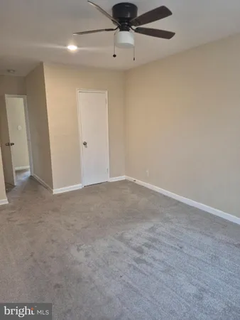 an empty room with a ceiling fan and window