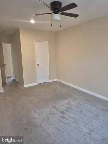an empty room with a ceiling fan and window