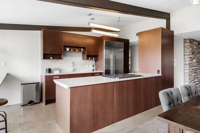 a kitchen with stainless steel appliances kitchen island granite countertop a refrigerator and a sink