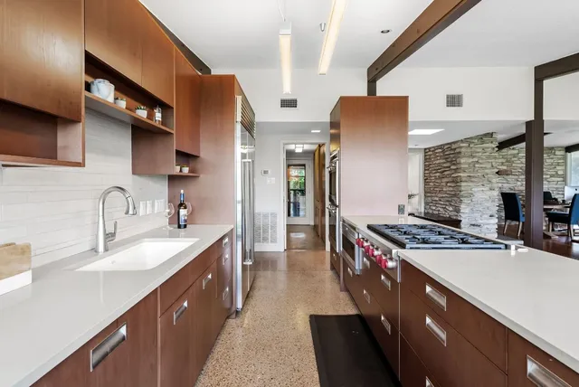 a kitchen with stainless steel appliances granite countertop a sink stove and refrigerator
