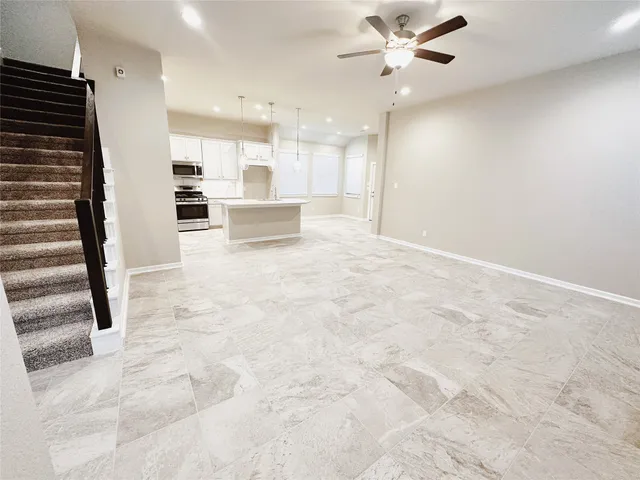 a view of a kitchen with wooden cabinet and a ceiling fan