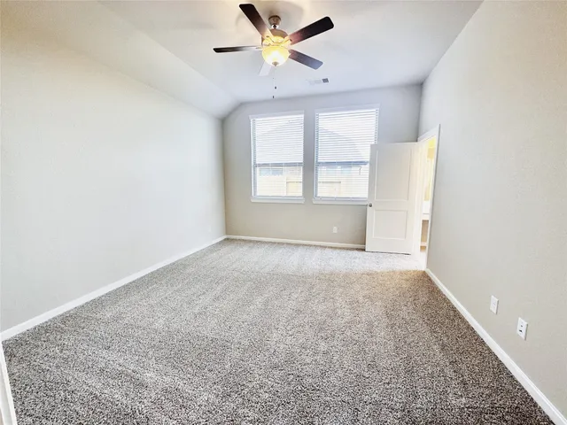 an empty room with windows and a ceiling fan