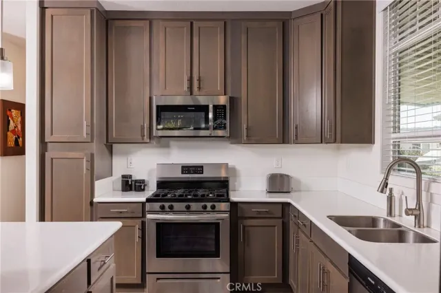 a kitchen with stainless steel appliances a stove a sink and a microwave