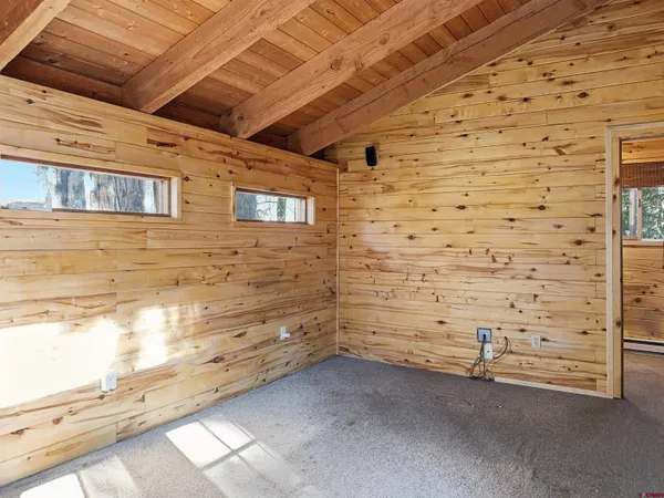 a living room with furniture a flat screen tv and floor to ceiling window