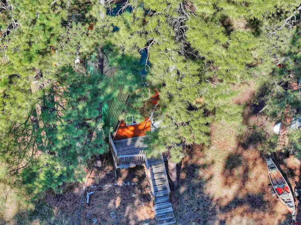 an aerial view of residential house with outdoor space and trees all around