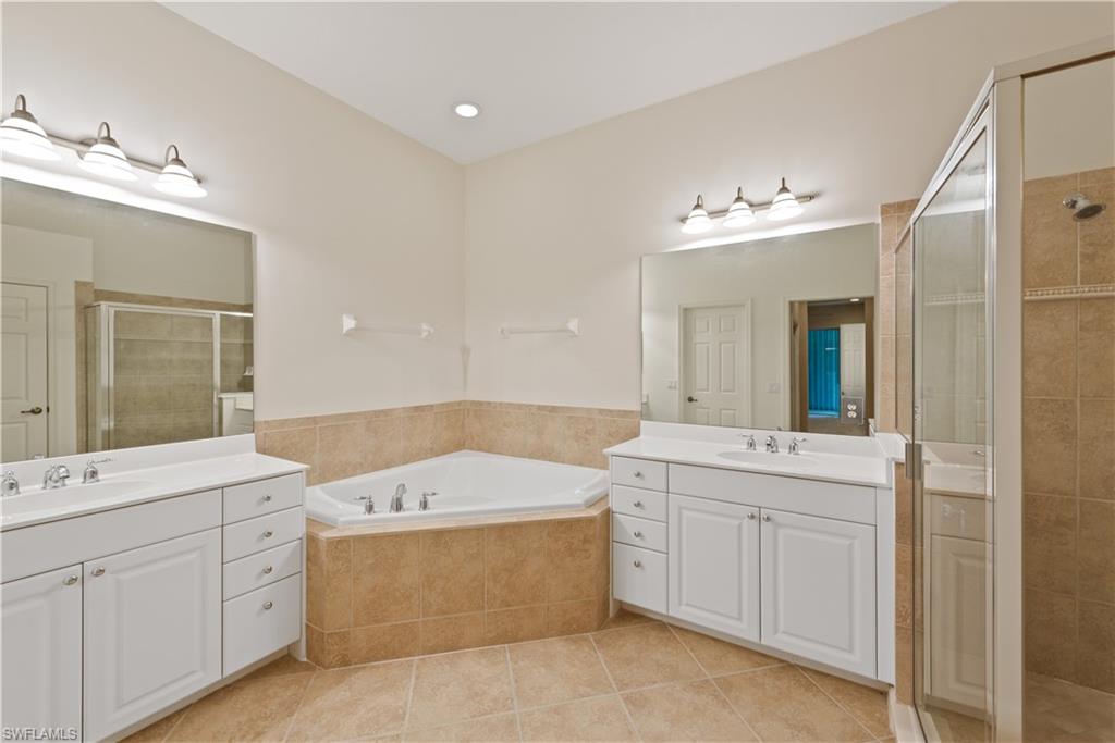 26425 Lucky Stone Road, Unit 201 Bonita Springs, FL 34135 - Photo 13 of 22 a bathroom with a double vanity sink mirror and bathtub