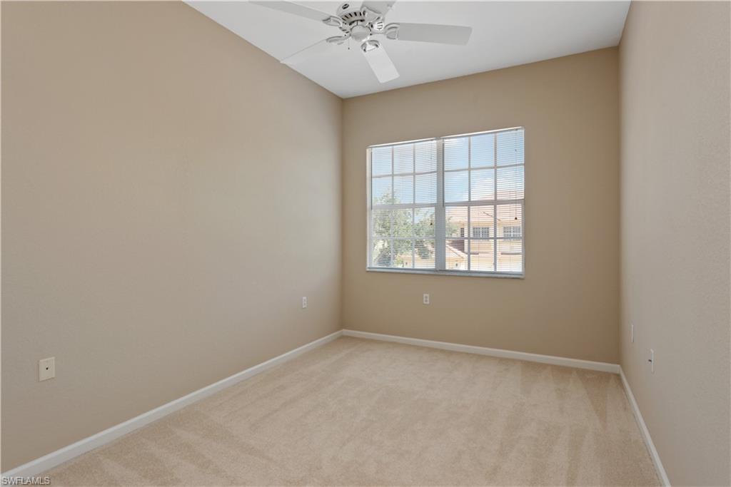 26425 Lucky Stone Road, Unit 201 Bonita Springs, FL 34135 - Photo 14 of 22 an empty room with a window and a ceiling fan