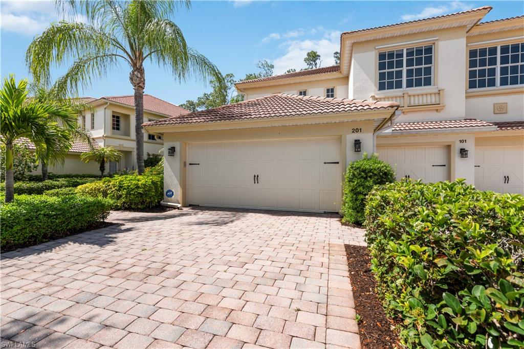 26425 Lucky Stone Road, Unit 201 Bonita Springs, FL 34135 - Photo 2 of 22 a view of a white house with a yard and potted plants