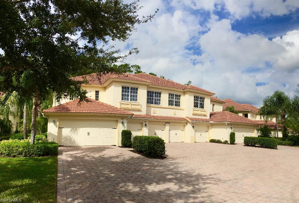26425 Lucky Stone Road, Unit 201 Bonita Springs, FL 34135 - Photo 3 of 22 a front view of a house with a yard and garage