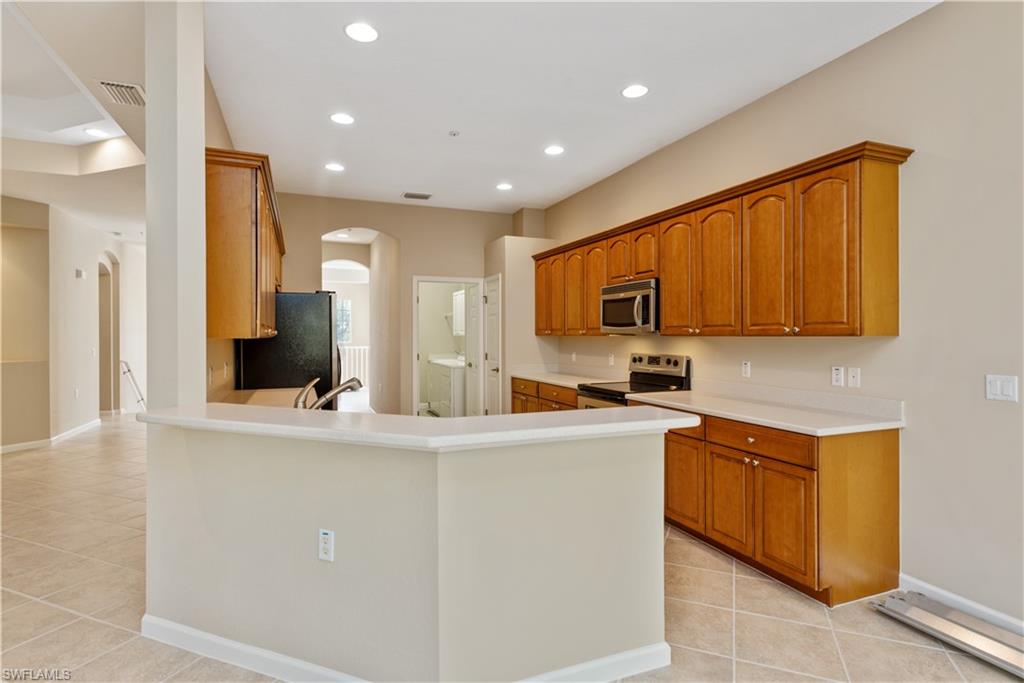 26425 Lucky Stone Road, Unit 201 Bonita Springs, FL 34135 - Photo 4 of 22 a kitchen with stainless steel appliances granite countertop a sink and cabinets