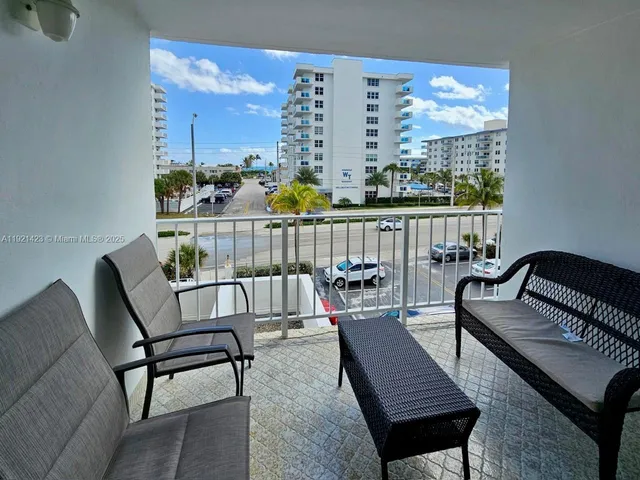 a view of a balcony with two chairs and a potted plant
