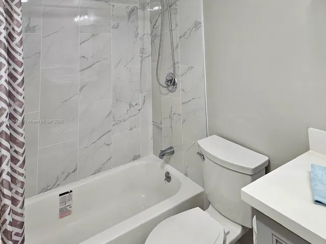 a white toilet sitting next to a bath tub