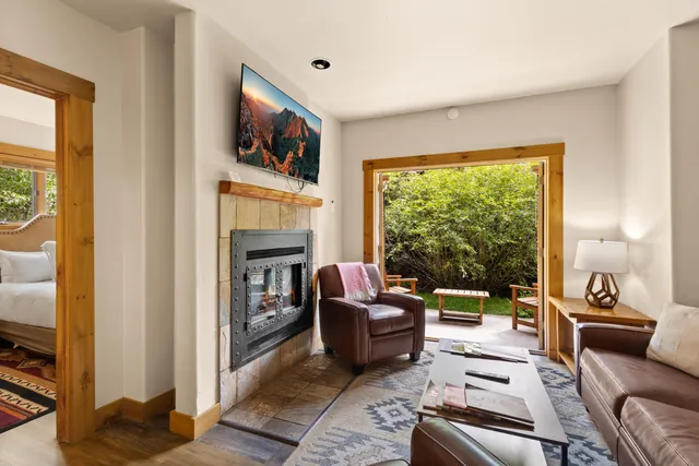 a living room with fireplace furniture and a large window
