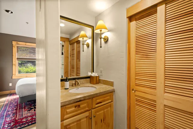 a bathroom with a granite countertop sink and a mirror