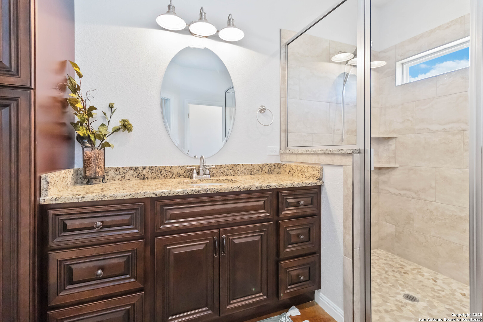 342 Wood View Circle Bandera, TX 78003 - Photo 25 of 45 a bathroom with a granite countertop sink a mirror and a shower