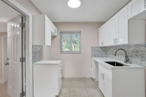 a kitchen with a sink cabinets and window