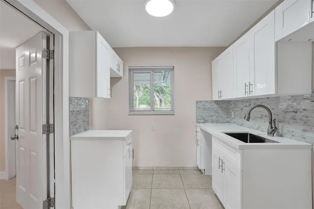 a kitchen with a sink cabinets and window