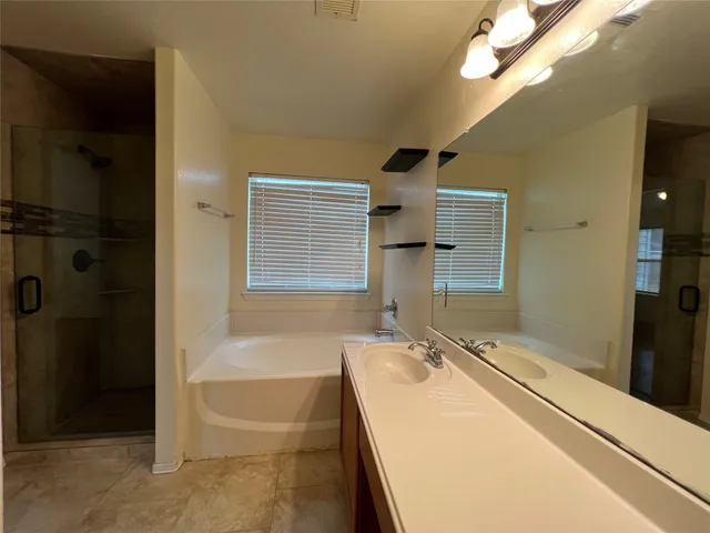 a bathroom with a granite countertop sink a mirror and a bathtub