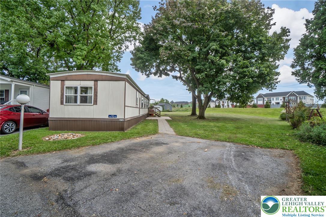 8721 Turkey Ridge Road Breinigsville, PA 18031 - Photo 3 of 30 Mature trees frame the spacious lawn and paved driveway leading to this classic manufactured home.