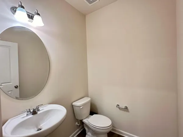 a bathroom with a sink mirror and toilet