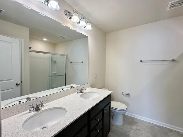 a bathroom with a double vanity sink mirror and toilet