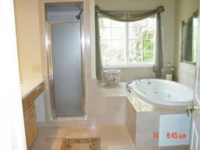 a bathroom with a tub a sink and a mirror