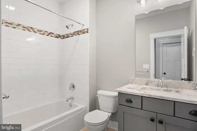 a view of hallway with window and wooden floor