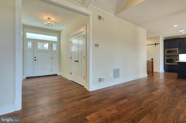 a kitchen with kitchen island granite countertop a refrigerator a sink and wooden floor