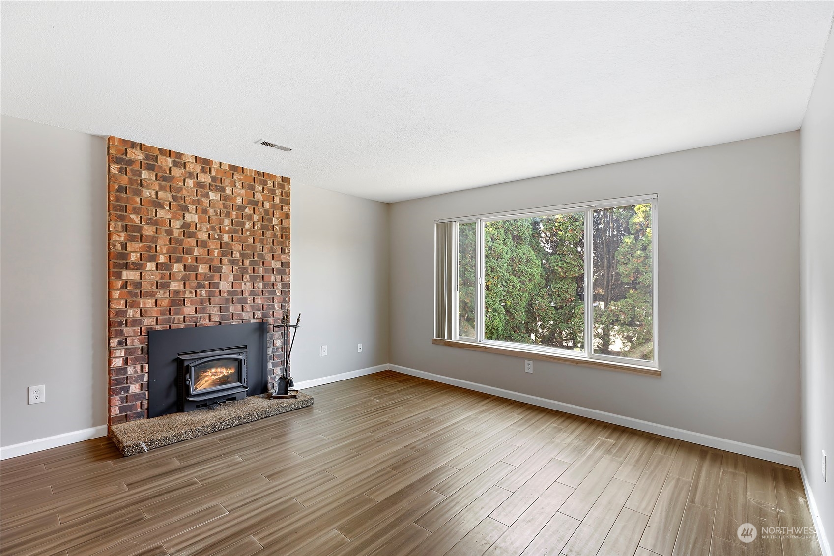 7209 6th Avenue West Everett, WA 98203 - Photo 11 of 27 a view of an empty room with wooden floor fireplace and a window